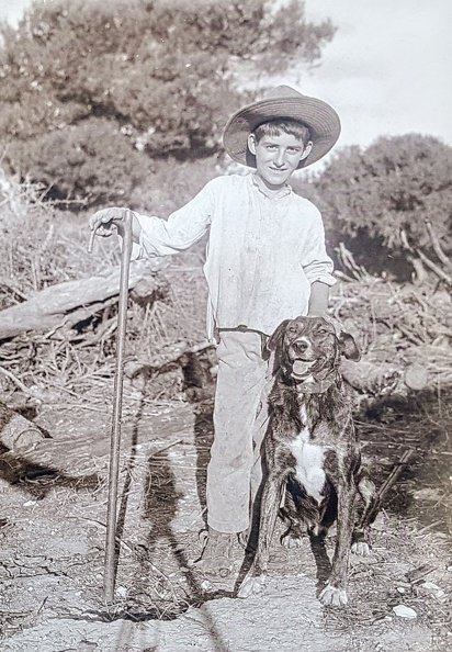 A young boy in a straw hat stands confidently in vintage rural attire next to his loyal dog, against a backdrop of trees, showcasing an earlier, simpler time in majorca 20171209_101319~2.jpg