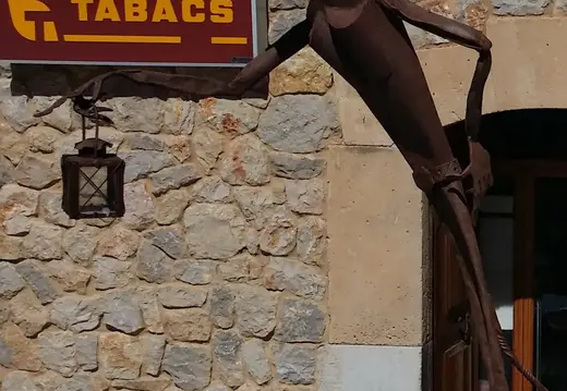 Metal Figure by a Tabacs Sign in Lloret de Vistalegre