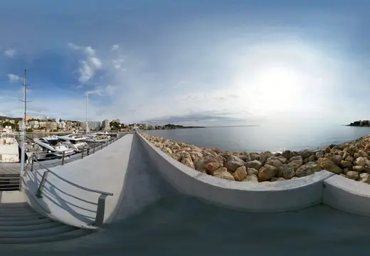 Passerella in cemento e frangiflutti roccioso a Cala Nova Marina