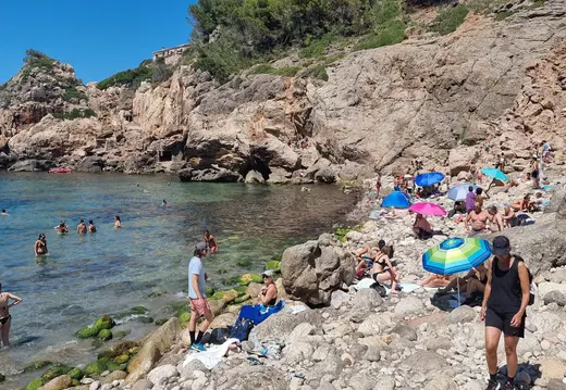 Schwimmer und Kieselsteine in Cala Deià