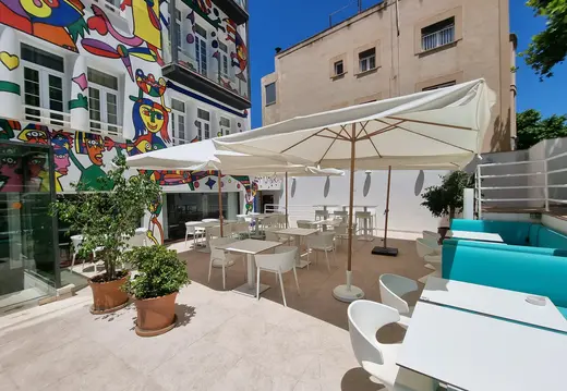 Restaurant Terrasse neben einem bunten Wandgemälde