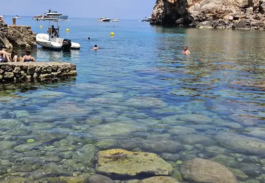 Boote und Schwimmer in Cala Deià