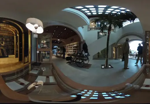 Interno di una biblioteca con scaffali storici ed esposizioni