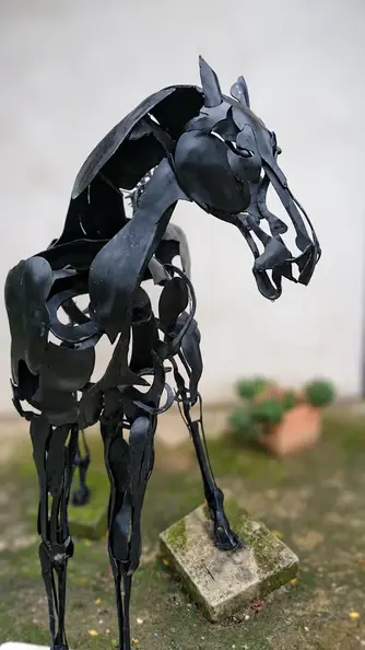 Black scrap-metal horse in soft focus.webp