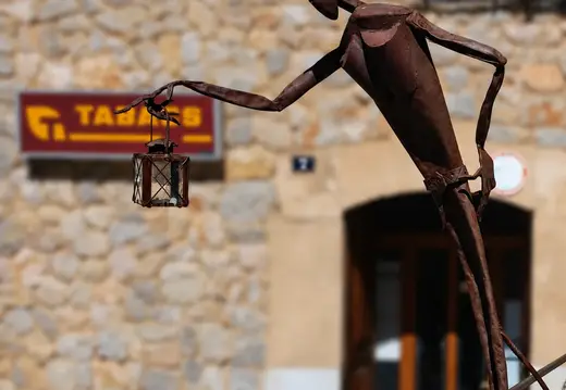 Figura in metallo che tiene una lanterna