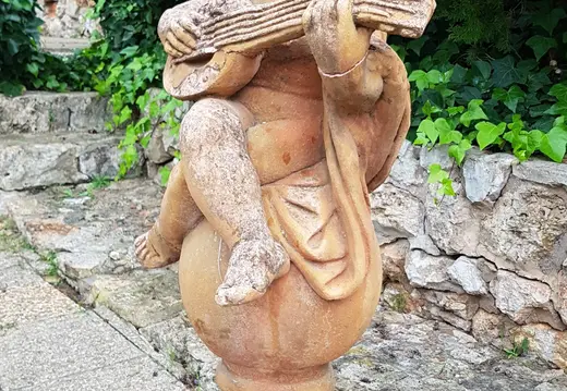 Figura che suona il mandolino in un giardino a Bendinat