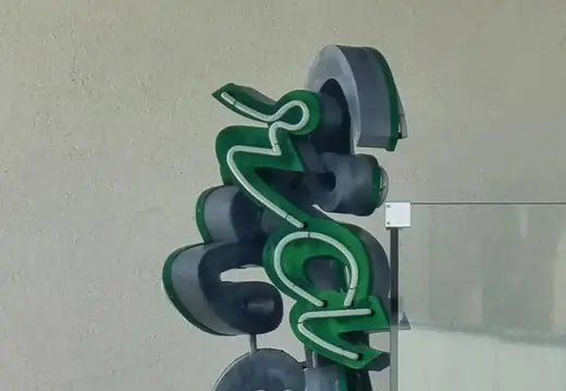 Scultura lettera verde a Cala Major