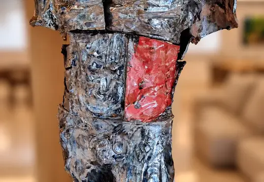 Torso in metallo riflettente con un pannello rosso