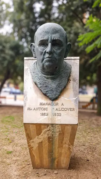 Bronze bust with blurred park.webp
