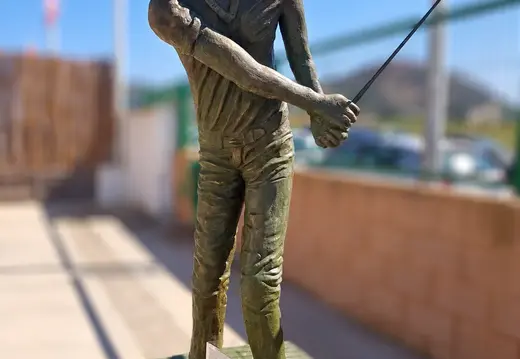 Scultura di un golfista con la mazza alzata