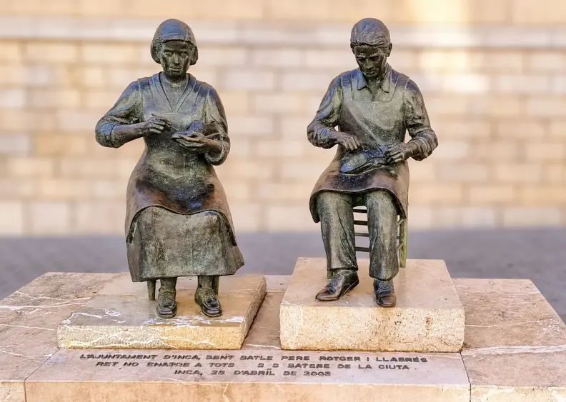Bronze shoemakers, softly blurred backdrop.webp