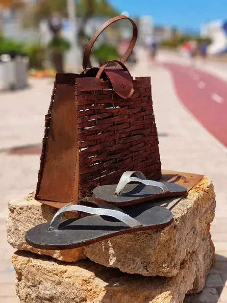 Rusty metal handbag and sandals in focus.webp